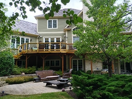 a large home in Woodridge, IL with a raised deck and patio area